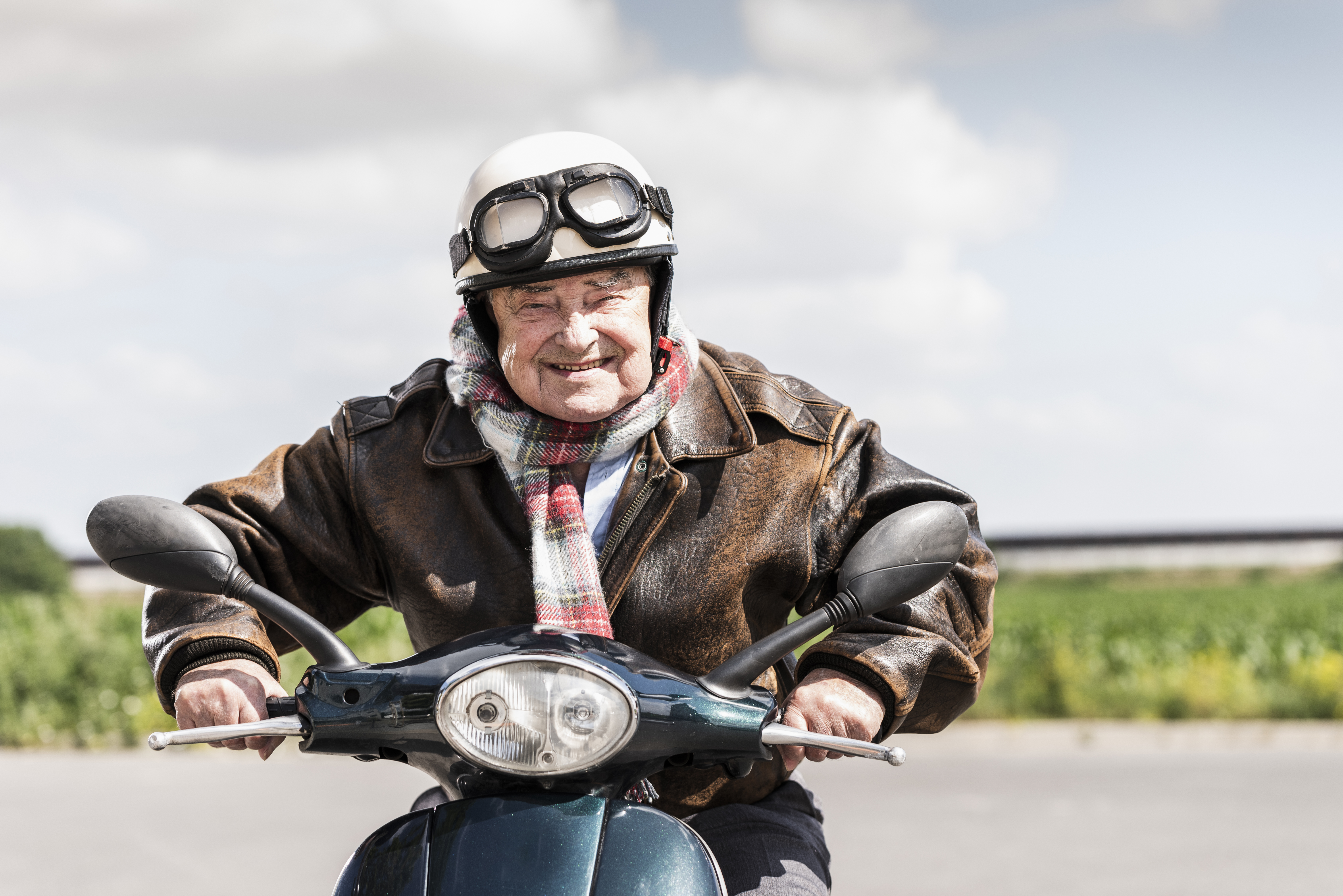 Active senior man speeding on his motor scooter